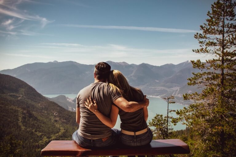 A couple sitting on a bench overlooking a scenic mountain view, symbolizing peace and reflection, shared by Bible Digest.